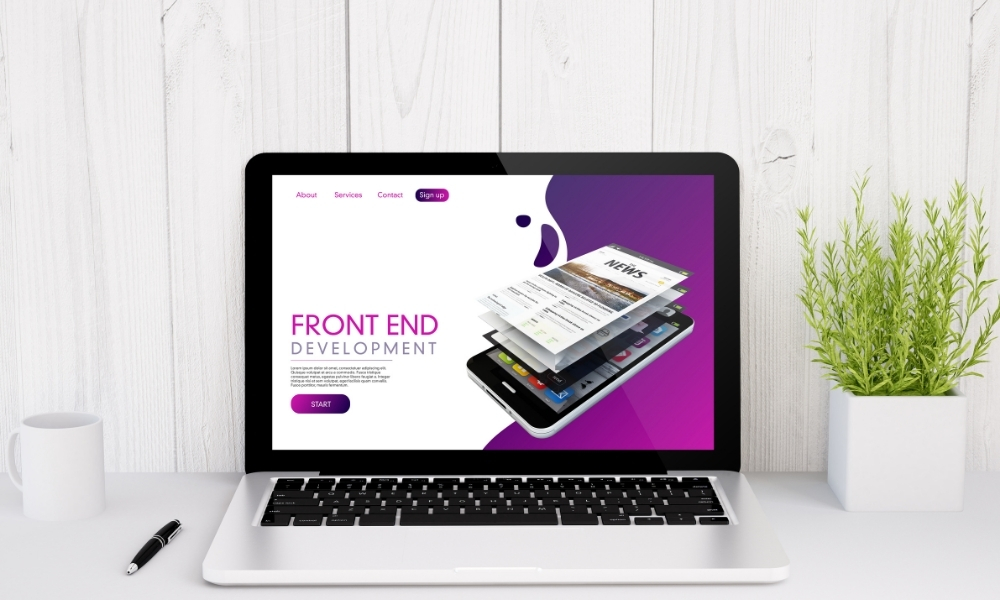 Laptop displaying a website design for 'Front End Development' on a white desk, illustrating how long to build a website.